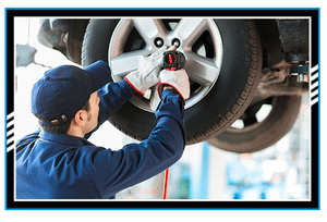 Mechanician changing car wheel in auto repair shop