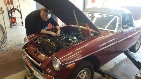 Mechanic doing work on red car